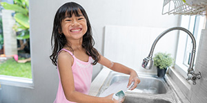Young girl washing dishes