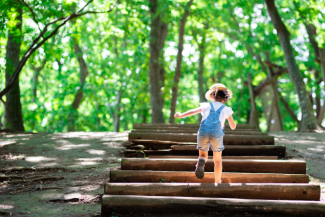 Girl running up stairs in forest